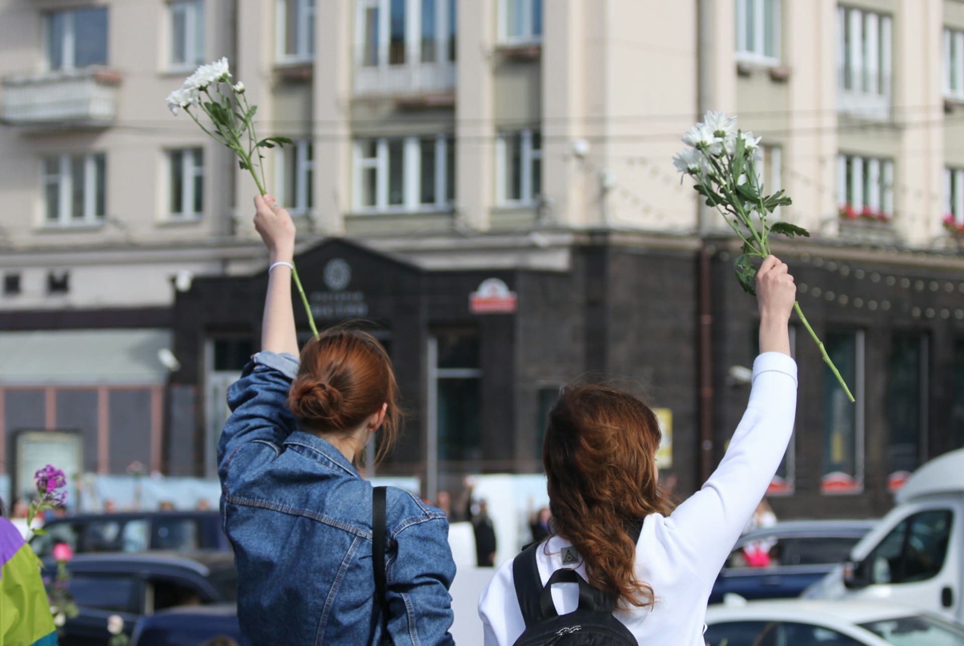 Mulheres com flores brancas nas mãos representando a cultura de paz.
